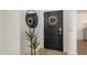 View of the dark wood front door with a wreath, a large decorative mirror, and a potted plant at 15018 S 28Th St, Phoenix, AZ 85048