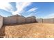 Large dirt backyard with block fence, offering privacy and potential for landscaping and outdoor activities at 17057 W Seldon Ln, Waddell, AZ 85355