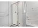 A luxurious bathroom features a glass-enclosed shower, a soaking tub, and bright white walls at 17057 W Seldon Ln, Waddell, AZ 85355