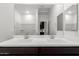 Contemporary bathroom featuring double sinks, dark wood cabinets, and a large mirror at 17057 W Seldon Ln, Waddell, AZ 85355
