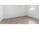 Bright bedroom with light colored wood-look flooring, white walls, and a window at 17057 W Seldon Ln, Waddell, AZ 85355