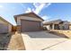 Two car garage with brown door, with a long concrete driveway and desert landscaping at 17057 W Seldon Ln, Waddell, AZ 85355