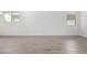 Bright living room featuring wood-look tile flooring and ample natural light from the strategically placed windows at 17057 W Seldon Ln, Waddell, AZ 85355