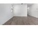Bright living room with light colored wood-look flooring, white walls, and a window at 17057 W Seldon Ln, Waddell, AZ 85355