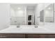 Bathroom featuring dual sinks, a large mirror, shower, and modern fixtures at 17081 W Seldon Ln, Waddell, AZ 85355