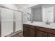 Bathroom featuring dual sinks, a glass enclosed shower, and a large mirror at 17081 W Seldon Ln, Waddell, AZ 85355