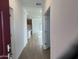 Bright entryway with wood-look tile flooring that leads into the open-concept kitchen and living space at 17081 W Seldon Ln, Waddell, AZ 85355