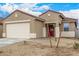 Exterior view of home with desert landscaping, red door and 2 car garage at 17081 W Seldon Ln, Waddell, AZ 85355