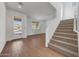 Bright entryway featuring wood floors, stairs, and a front door view of the home's exterior at 17313 W Via Dona Rd, Surprise, AZ 85387