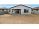 This backyard features a covered patio area, a privacy fence, and a sliding glass door at 17322 W Via Dona Rd, Surprise, AZ 85387