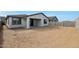 A view of the home's backyard including the covered patio and sliding glass doors at 17322 W Via Dona Rd, Surprise, AZ 85387