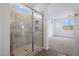 Tiled shower with glass door in a bright bathroom; a cozy bedroom in the background at 17322 W Via Dona Rd, Surprise, AZ 85387