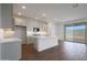 Well-lit kitchen features white cabinets, island, and sliding glass door leading to backyard at 17322 W Via Dona Rd, Surprise, AZ 85387