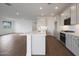 Open-concept kitchen with white cabinets, island, and stainless steel appliances at 17322 W Via Dona Rd, Surprise, AZ 85387