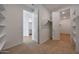 Bedroom with neutral carpet, an open doorway to the bathroom, and views into the walk-in closet at 17445 W Via Dona Rd, Surprise, AZ 85387
