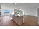 Kitchen island with granite countertops, double sink, stainless steel appliances, and wood-look tile flooring at 17445 W Via Dona Rd, Surprise, AZ 85387