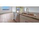 Granite counters grace a stainless sink and dishwasher on the kitchen island, all on wood-look tile at 17445 W Via Dona Rd, Surprise, AZ 85387