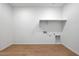 Bright laundry room with durable flooring, modern hookups, and built in shelving providing convienent storage at 17445 W Via Dona Rd, Surprise, AZ 85387