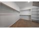 A walk-in closet with adjustable shelving and neutral carpet offers ample storage space at 17445 W Via Dona Rd, Surprise, AZ 85387