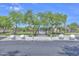 Community pool entrance featuring lush trees, landscaping, and convenient parking at 17619 W Oberlin Way, Surprise, AZ 85387