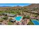 Aerial view of community pool, tennis courts, and clubhouse against a mountain backdrop at 1821 W Morse Dr, Anthem, AZ 85086