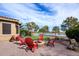 Backyard with putting green, patio with fire pit, comfortable seating, and attractive desert landscaping at 20623 N Enchantment Pass, Maricopa, AZ 85138