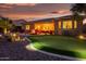 Expansive backyard showcasing a putting green, a cozy patio, and picturesque landscaping perfect for outdoor living and entertaining at 20623 N Enchantment Pass, Maricopa, AZ 85138