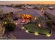 Backyard features a putting green, patio with fire pit, desert landscaping, and exterior of the house at 20623 N Enchantment Pass, Maricopa, AZ 85138