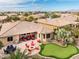 Expansive backyard featuring a putting green, a paved patio with a fire pit, and desert landscaping at 20623 N Enchantment Pass, Maricopa, AZ 85138