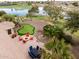 Outdoor oasis with a putting green, fire pit, outdoor dining, and a beautiful lake view at 20623 N Enchantment Pass, Maricopa, AZ 85138