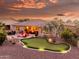 Backyard with putting green, patio with fire pit, desert landscaping, and pleasant outdoor living space at 20623 N Enchantment Pass, Maricopa, AZ 85138