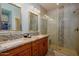 Bathroom with dual sinks, granite countertops, glass shower, and tile accents at 20623 N Enchantment Pass, Maricopa, AZ 85138