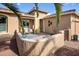Charming front courtyard with an outdoor seating area and manicured desert landscaping at 20623 N Enchantment Pass, Maricopa, AZ 85138