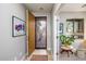 Welcoming foyer with an open door showcasing a decorative security door and a glimpse into a sunlit room with plant decor at 20623 N Enchantment Pass, Maricopa, AZ 85138