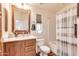 Well-lit bathroom featuring a wooden vanity, a tiled shower with a curtain, and fixtures at 2206 S Ellsworth Rd # 149B, Mesa, AZ 85209