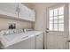 Clean laundry room featuring a modern white washer and dryer, and overhead storage cabinets at 2206 S Ellsworth Rd # 149B, Mesa, AZ 85209