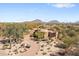 Breathtaking aerial view of the home showcasing its desert landscape and the mountain views at 25433 N Bronco Trl, Scottsdale, AZ 85255