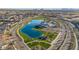 Aerial view of a community pool and lake surrounded by green space, walking trails, and residential homes at 25582 S 224Th Way, Queen Creek, AZ 85142