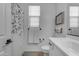 Bright bathroom with toilet, white cabinets, decorative towels, and a shower with leafy curtain at 25582 S 224Th Way, Queen Creek, AZ 85142