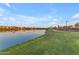 Scenic community lake with walking path, lush green grass, and serene water views at sunset at 25582 S 224Th Way, Queen Creek, AZ 85142