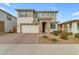 Charming two-story home showcasing stone accents, manicured landscaping, and a brick paver driveway at 25582 S 224Th Way, Queen Creek, AZ 85142
