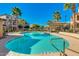 Community pool with blue water, palm trees, seating, and lush landscaping at 2821 S Skyline Dr # 134, Mesa, AZ 85212