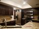 Modern kitchen with stainless steel appliances, granite countertops, and dark wood cabinetry at 3030 N Hayden Rd # 28, Scottsdale, AZ 85251