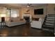 Inviting living room with a cozy fireplace, large windows, modern ceiling fan and unique slate stairs at 3030 N Hayden Rd # 28, Scottsdale, AZ 85251