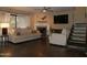 Modern living room with fireplace, staircase and TV, all bathed in warm, inviting light at 3030 N Hayden Rd # 28, Scottsdale, AZ 85251