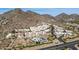 Gorgeous aerial view of desert community with mountain views, a tennis court, and community pool at 3800 E Lincoln Dr # 7, Phoenix, AZ 85018