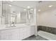 Bright bathroom with a dual sink vanity, white cabinets, and a soaking tub at 3800 E Lincoln Dr # 7, Phoenix, AZ 85018