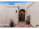 Inviting front entrance with arched double doors, potted plants, and a decorative lantern at 3800 E Lincoln Dr # 7, Phoenix, AZ 85018