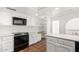 Kitchen featuring white cabinets, black appliances, and terracotta tile flooring at 3800 E Lincoln Dr # 7, Phoenix, AZ 85018