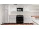 Kitchen featuring white cabinets, black appliances, and terracotta tile flooring at 3800 E Lincoln Dr # 7, Phoenix, AZ 85018